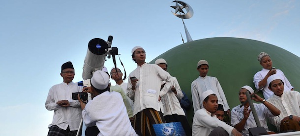 Indonesian Muslim men prepare to sight the new moon from the rooftop of the Al-Hidayah Basmol mosque in Jakarta on July 8, 2013 in preparation for the beginning of the Muslim holy fasting month of Ramadan. The start of the holy month of Ramadan, when the faithful abstain from eating from dawn to sunset, is determined by the sighting of the new moon. AFP PHOTO / ROMEO GACAD (Photo credit should read ROMEO GACAD/AFP/Getty Images)