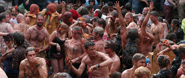 GLASTONBURY, ENGLAND - JUNE 30: People take part in a tomato fight at the Common at the Glastonbury Festival of Contemporary Performing Arts site at Worthy Farm, Pilton on June 30, 2013 near Glastonbury, England. Gates opened on Wednesday at the Somerset dairy farm that will be playing host to one of the largest music festivals in the world and this year features headline acts Artic Monkeys, Mumford and Sons and the Rolling Stones. Tickets to the event which is now in its 43rd year sold out in minutes and that was before any of the headline acts had been confirmed. The festival, which started in 1970 when several hundred hippies paid 1 GBP to watch Marc Bolan, now attracts more than 175,000 people over five days. (Photo by Matt Cardy/Getty Images)