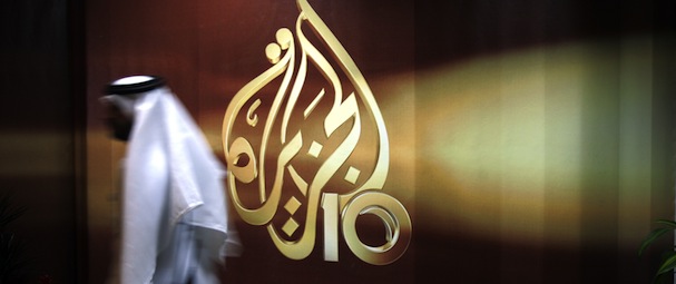 A Qatari employee of Al Jazeera Arabic language TV news channel passes by the logo of Al Jazeera in Doha, Qatar, Wednesday Nov. 1, 2006. The English language offshoot of Qatar based pan-Arab television news channel Al Jazeera said on Tuesday it will start broadcasting on November 15, 2006. (AP Photo/Kamran Jebreili)