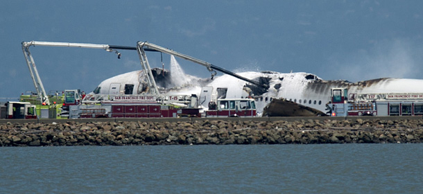 A fire truck sprays water on Asiana Flight 214 after it crashed at San Francisco International Airport on Saturday, July 6, 2013, in San Francisco. (AP Photo/Noah Berger)