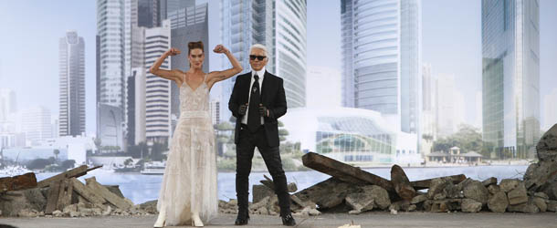 German fashion designer Karl Lagerfeld, right, stands by a model as he acknowledges applause following the presentation of the Haute Couture Fall-Winter 2013-2014 collection he designed for Chanel, Tuesday, July 2, 2013 in Paris. (AP Photo/Francois Mori)