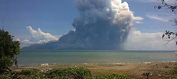 The photo taken from the Maurole district of East Nusa Tenggara province with a camera phone shows Mount Rokatenda volcano spewing a huge column of hot ash during an eruption on August 10, 2013. The volcano erupted in central Indonesia on August 10, spewing hot ash and rocks high into the air and killing five people, an official said. Mount Rokatenda, on the tiny island of Palue, sent fast-moving red-hot ash onto a nearby beach, leaving three adults and two children dead, said vulcanology centre head Surono. AFP PHOTO (Photo credit should read STR/AFP/Getty Images)