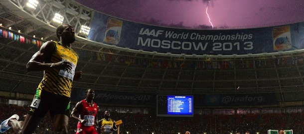 Jamaica's Usain Bolt (L) wins the100 metres final at the 2013 IAAF World Championships at the Luzhniki stadium in Moscow on August 11, 2013 while a lightning strikes in the sky. Bolt timed a season's best 9.77 seconds, with American Justin Gatlin claiming silver in 9.85sec and Nesta Carter, also of Jamaica, taking bronze in 9.95sec. 
 AFP PHOTO / OLIVIER MORIN (Photo credit should read OLIVIER MORIN/AFP/Getty Images)