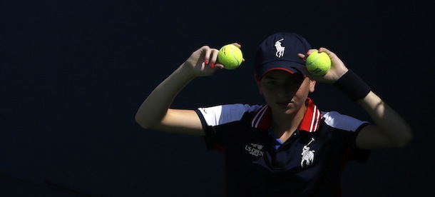 A member of the U.S. Open staff holds up balls for service during a first-round match at the U.S. Open tennis tournament on Tuesday, Aug. 27, 2013, in New York. (AP Photo/David Goldman)
