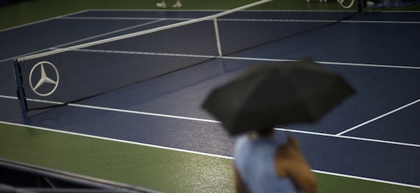 A spectator waits during a rain delay during the third day of play at the 2013 U.S. Open tennis tournament, Wednesday, Aug. 28, 2013, in New York. (AP Photo/David Goldman)