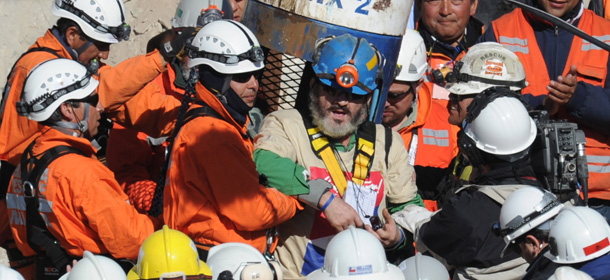 Chilean miner Jorge Galleguillos (C) upon exiting the Fenix capsule after being brought to the surface in the eleventh place, on October 13, 2010 following a 10-week ordeal in the collapsed San Jose mine, near Copiapo, 800 km north of Santiago, Chile. AFP PHOTO/ Rodrigo ARANGUA (Photo credit should read RODRIGO ARANGUA/AFP/Getty Images)
