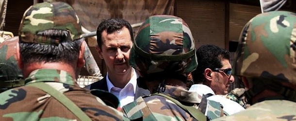 FILE - This file image posted on the official Facebook page of the Syrian Presidency on Thursday, Aug. 1, 2013 purports to show Syrian President Bashar Assad talking with soldiers with during Syrian Arab Army day in Darya, Syria. More than two years into Syria's civil war, the once highly-centralized authoritarian state has effectively split into three distinct parts, each boasting its own flags, security agencies and judicial system. (AP Photo/Syrian Presidency via Facebook, FIle)