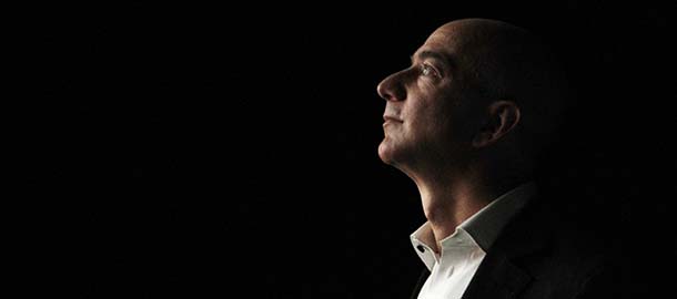 Jeff Bezos, CEO and founder of Amazon, is illuminated by a display screen at the introduction of the new Amazon Kindle Fire HD and Kindle Paperwhite in Santa Monica, Calif., Thursday, Sept. 6, 2012. (AP Photo/Reed Saxon)
