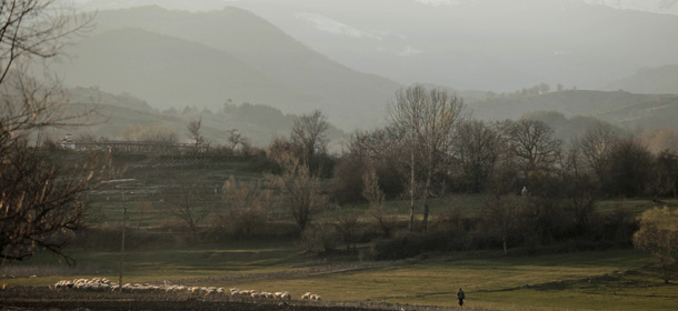 This Wednesday, March 28, 2012 photo shows a general view of the village of Kornitsa, Bulgaria as a shepherd herds his flock. On March 28, 1973 police and army units stormed the village and opened fire on hundreds at people gathered in the square to protest the communist regime's campaign to force Bulgaria's Muslims to adopt non-Islamic names and break up their communities. The brutal crackdown left five men dead and more than 100 wounded. More than 70 families were forced to leave their homes and settle in remote villages. (AP Photo/Valentina Petrova)