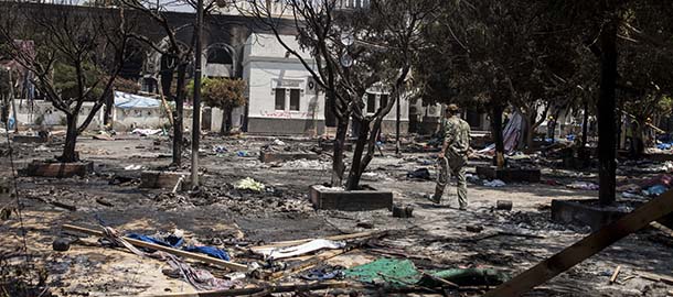 CAIRO, EGYPT - AUGUST 15: An Egyptian soldier walks through the burnt-out grounds of the Rabaa al-Adaweya Mosque in Nasr City on August 15, 2013 in Cairo, Egypt. An unknown number of pro-Morsi protesters were killed in Egypt's capital yesterday as Egyptian Security Forces undertook a planned operation to clear Morsi supporters from two sit-in demonstrations in Cairo where they have camped for over one month. Egyptian Police and Army forces entered protest sites in the Nasr City and Giza districts at dawn on August 14, using tear gas, live fire and bulldozers to disperse protesters and destroy the camps. A state of emergency has been declared in Egypt that began yesterday afternoon and will last for one month. (Photo by Ed Giles/Getty Images)