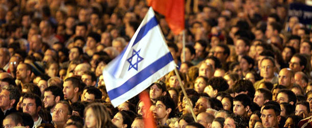 Holding up their national flag, thousands of Israelis gather to attend a rally on the 10th anniversary of the assassination of former Prime Minister Yitzhak Rabin, in Tel Aviv, 12 November 2005. Thousands of Israelis flooded into the Tel Aviv square where a Jewish extremist murdered premier Rabin 10 years ago, to commemorate the anniversary of his killing. The general-turned-peacemaker, who inspired both admiration and hatred for signing the 1993 Oslo autonomy accords with the Palestinians, was shot in the back on November 4, 1995 after a peace rally in a square now bearing his name. AFP PHOTO/YOAV LEMMER (Photo credit should read YOAV LEMMER/AFP/Getty Images)