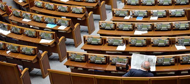A deputy of majority reads a newspaper as he sits alone in the Ukrainian parliament prior a session in Kiev on June 7, 2013. Opposition deputies blocke proceeding and demand the presence of Presidenr Viktor Yanukovych to deliver the annual President's message to the parliament. AFP PHOTO/ SERGEI SUPINSKY (Photo credit should read SERGEI SUPINSKY/AFP/Getty Images)