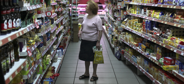 A woman looks at food stacked on shelves in a supermarket in Lisbon, Monday, July 8, 2013. Carlos Capelo, who is the owner of the supermarket, claimed that his business' incomes have decreased around 25 percent in the last three years, highlighting that customers buy essential food products and less meat and fruit. The bailout program of spending cuts, including steep tax hikes and pay and pension cuts, and economic reforms which are scrapping long-standing labor rights is due to be completed by June 2014. It is supposed to restore investor confidence in Portugal so that Lisbon can start borrowing again on international markets, but the political spat amplified fears the Portuguese will need more financial aid beyond next year. (AP Photo/Francisco Seco)