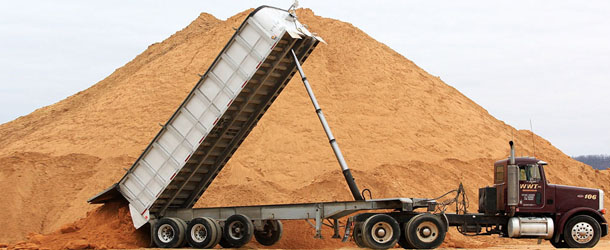 FILE - In a Feb. 13, 2012 file photo, a truck dumps a load of silica sand at Modern Transport Rail loading terminal in Winona, Minn. Critics of silica sand mining had hoped the Minnesota Legislature would adopt aggressive statewide rules to protect people and the environment. However, what emerged from the just finished session was a compromise that leaves much of the authority for deciding how and whether to regulate the industry up to local governments. (AP Photo/The Winona Daily News, Andrew Link,File) MANDATORY CREDIT