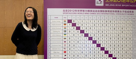 Chess player Hou Yifan of China stands beside a scoreboard following her win in a 'blinfold' chess tournament at the Beijing 2012 World Mind Games Tournament in Beijing on December 19, 2012. Some of the world's top chess players went eye-to-eye in the year's highest-level "blindfold" chess tournament -- seen by some as the toughest challenge in the game. Unable to physically see their own or their opponent's past moves, the players summoned headache-inducing levels of concentration to fight for gold in a silent conference room, lined up in front of laptop screens showing a blank board. AFP PHOTO / Ed Jones (Photo credit should read Ed Jones/AFP/Getty Images)