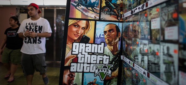 A man walks past a billboard of the "Grand Theft Auto V" video game in Hong Kong on September 17, 2013. The game hit the streets in the former British colony as it launched worldwide on September 17, 2013 in respective time zones. AFP PHOTO / Philippe Lopez (Photo credit should read PHILIPPE LOPEZ/AFP/Getty Images)