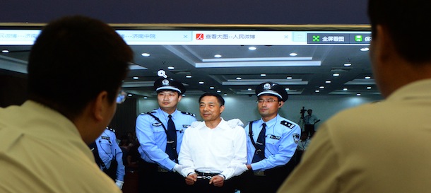 Staff look at an image of disgraced politician Bo Xilai at the Intermediate People's Court after being sentenced to life in prison when his verdict was announced in Jinan, Shandong Province on September 22, 2013. Fallen Chinese political star Bo Xilai was sentenced by a court to life in prison, following a sensational scandal that culminated in the country's highest-profile trial in decades. AFP PHOTO/Mark RALSTON (Photo credit should read MARK RALSTON/AFP/Getty Images)