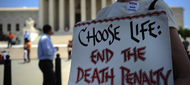 An anti-death penalty activist passes out pamphlets during a rally outside the US Supreme Court to mark historic court rulings on the issue June 29, 2009 in Washington, DC. AFP PHOTO / Tim Sloan (Photo credit should read TIM SLOAN/AFP/Getty Images)
