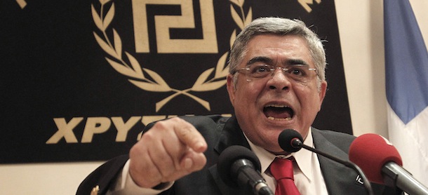 In this file photo, Golden Dawn leader Nikolaos Michaloliakos speaks during a news conference in front of a banner with the twisting Maeander, an ancient Greek decorative motif that the party has adopted as its symbol in Athens, Sunday, May 6, 2012. Greek police say the leader of the extreme right Golden Dawn party, Nikos Mihaloliakos, has been arrested on Saturday Sept.28, 2013, on charges of forming a criminal organization. Warrants for the arrest of another five Golden Dawn parliament deputies have been issued. The police counterterrorism unit is looking for the deputies. More warrants are expected.The arrests come several days after the killing of a left-wing activist rapper by an alleged Golden Dawn member.(AP Photo/Petros Giannakouris)