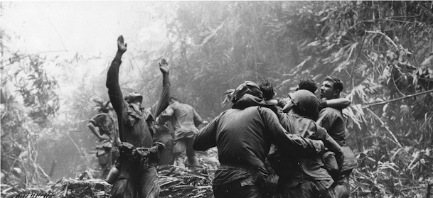 As fellow troopers aid wounded buddies, a paratrooper of A Company, 101st Airborne, guides a medical evacuation helicopter through the jungle foliage to pick up casualties during a five-day patrol of Hue, South Vietnam, in April, 1968. (AP Photo/Art Greenspon)