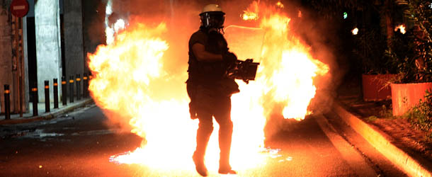 A molotov coctail explodes in front of riot police on September 25, 2013 during clashes with demonstrators in Athens. Police clashed with protesters in Athens late September 25 at the end of a huge march sparked by the murder of an anti-fascist musician, allegedly at the hands of a self-confessed neo-Nazi. Protesters were seen hurling petrol bombs at riot police, who responded with tear gas a few hundred meters (yards) from the headquarters of the neo-Nazi party Golden Dawn. AFP PHOTO / ARIS MESSINIS (Photo credit should read ARIS MESSINIS/AFP/Getty Images)