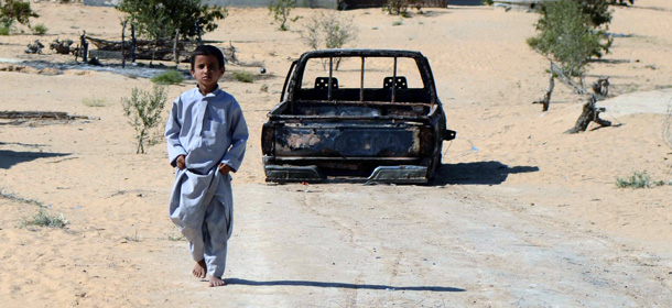 An Egyptian child walks in front of the wreckage of a burnt down car, the day after an attack by Egyptian Army in a village on the outskirt of the Northern Sinai town of Sheik Zuweid on September 10, 2013 in Egypt. A series of attacks in Egypt's restive Sinai peninsula over the past 24 hours, mostly against soldiers, killed at least four people, security officials said. The violence comes as the Egyptian military presses its campaign in Sinai to quell an insurgency that surged after the army overthrew Islamist president Mohamed Morsi on July 3. AFP PHOTO/MOHAMED EL-SHAHED (Photo credit should read MOHAMED EL-SHAHED/AFP/Getty Images)