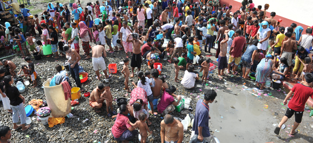 Residents affected by the stand-off between government forces and Muslim rebels wash at an evacuation center inside n sports complex in Zamboanga, on the southern island of Mindanao on September 18, 2013. Dozens of people trapped in a deadly urban battle between Muslim rebels and Philippine troops rushed to safety on September 17, as the guerrillas lost ground in more heavy fighting, authorities said and nearly 70,000 other civilians have fled the fighting. AFP PHOTO/TED ALJIBE (Photo credit should read TED ALJIBE/AFP/Getty Images)