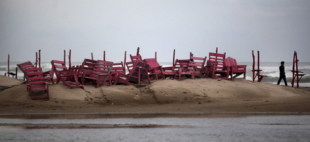 A man walks past tied up chairs at the Miramar beach as Hurricane Ingrid approaches the coast in Ciudad Madero, Mexico, Sunday Sept. 15, 2013. Tropical Storm Manuel swept onto Mexico's Pacific coast Sunday while Hurricane Ingrid swirled offshore on the other side of the country, as heavy rains and landslides caused at least 24 deaths and led authorities to evacuate thousands.(AP Photo/Felix Marquez)