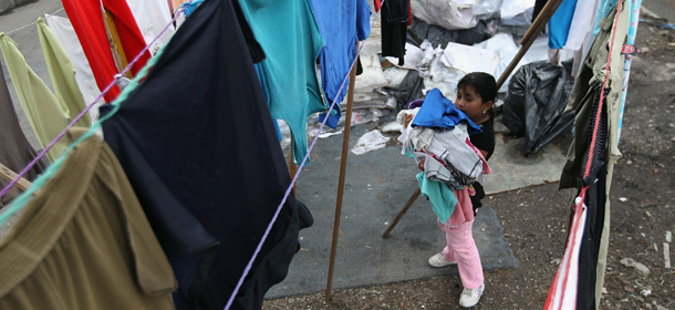 MEXICO CITY, MEXICO - JUNE 25: Maria de la Luz Espinosa, 8, collects damp laundry ahead of a rainstorm in a squatters village on June 25, 2012 in Mexico City, Mexico. Residents of the neighborhood, known as Telecommunications, moved onto the city property 6 years ago and live without running water, have little electricity and are subject to frequent flooding from rainstorms. Although incomes have risen nationwide in recent years, Mexico's vast income disparity is a major theme ahead of Sunday's upcoming presidential election. (Photo by John Moore/Getty Images)