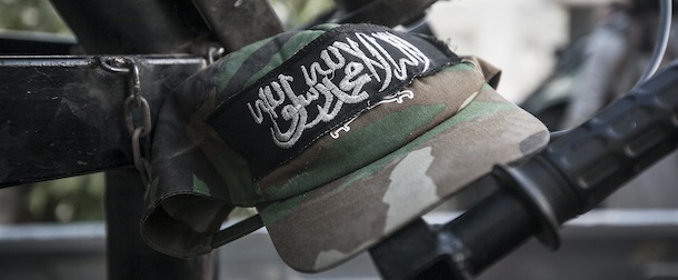 In this Friday, Sept. 20, 2013 photo, a military cap sewed with a patch in Arabic that reads, "there is no God but Allah and Mohammed is his prophet," hangs on an ordinance belonging to Free Syrian Army fighters during clashes with government forces in Kafr Nboudah village, Idlib province, northern Syria. In the village of Kafr Nboudah rebels associated with the Free Syrian Army, a group backed by the West, launched mortars and fired rocket propelled grenades to edge out regime forces from villages with Alaaite majorities. (AP Photo)