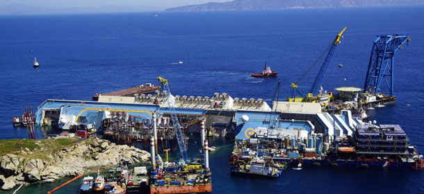 La nave Costa Concordia davanti all'Isola del Giglio e il cantiere allestito per i lavori preparatori in funzione del raddrizzamento (Alessandro La Rocca/LaPresse)