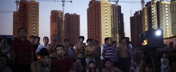 Migrant construction workers watch an open air movie near their dormitories after a shift at a residential construction site in Shanghai July 15, 2013. The construction site is among a new developing residential area located in Jiading district of suburban Shanghai, some 30 kilometres from the city centre. According to data from the World Bank, 68 percent of China's female population aged 15 and above participate in the labour force, compared to 58 percent in the United States, 51 percent in France, and 53 percent in Germany. Around a third of China's millions of rural-urban migrant workers are women and according to an academic paper published 2010, they also earn around a third less than their male equivalents. Picture taken July 15, 2013. REUTERS/Aly Song (CHINA - Tags: BUSINESS EMPLOYMENT SOCIETY CONSTRUCTION)

ATTENTION EDITORS: PICTURE 28 OF 29 FOR PACKAGE 'CHINA'S MIGRANT WORKFORCE'. TO FIND ALL IMAGES SEARCH 'RURAL-URBAN SONG'