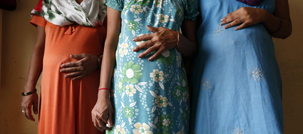 Surrogate mothers (L-R) Daksha, 37, Renuka, 23, and Rajia, 39, pose for a photograph inside a temporary home for surrogates provided by Akanksha IVF centre in Anand town, about 70 km (44 miles) south of the western Indian city of Ahmedabad August 27, 2013. India is a leading centre for surrogate motherhood, partly due to Hinduism's acceptance of the concept. The world's second test tube baby was born in Kolkata only two months after Louise Brown in 1978. Rising demand from abroad for Indian surrogate mothers has turned "surrogacy tourism" there into a billion dollar industry, according to a report by the Law Commission of India. Picture taken August 27, 2013. REUTERS/Mansi Thapliyal (INDIA - Tags: HEALTH SOCIETY TPX IMAGES OF THE DAY) 

ATTENTION EDITORS: PICTURE 18 33 FOR PACKAGE 'SURROGACY IN INDIA'
TO FIND ALL SEARCH 'SURROGACY ANAND'