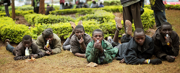 Street children watch media and others gather at a checkpoint near the Westgate Mall in Nairobi, Kenya, Wednesday Sept. 25 2013. Gunshots rang out from the upscale mall Wednesday morning, the day after the president declared an end to a four-day siege by Islamic militants. (AP Photo/Jerome Delay)