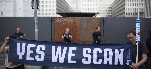 Demonstrators hold a banner during a protest against the supposed surveillance by the US National Security Agency, NSA, and the German intelligence agency, BND, during a rally in front of the construction site of the new headquarters of German intelligence agency in Berlin, Germany, Monday July 29, 2013. (AP Photo/Gero Breloer)