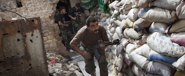 Rebel fighters duck as they run behind a barricade to avoid being fired at by Syrian regime forces in the Old City's front line in Aleppo on September 18, 2013. Damascus and key ally Moscow joined forces in a bid to thwart plans for a Western-backed UN resolution on Syria's chemical weapons that allows the use of force. The United States, meanwhile, said it will maintain the threat of force in case Syria's regime fails to abide by an agreement to relinquish control of its chemical weapons. AFP PHOTO/JM LOPEZ (Photo credit should read JM LOPEZ/AFP/Getty Images)