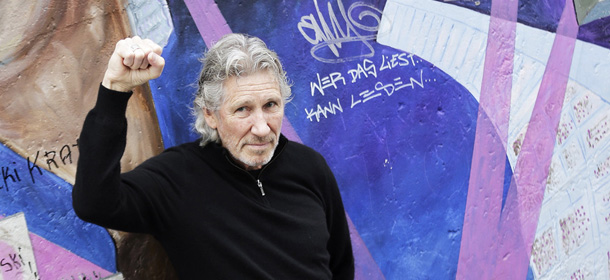 Roger Waters, co-founder of the British rock band Pink Floyd visits the 'East Side Gallery' a part of the former Berlin Wall in support of the efforts of the achievement of the last original remains, in Berlin, Thursday, Sept. 3, 2013. Massive protest happened in Berlin as parts of the former Berlin wall were taken away earlier this year for the construction of apartment buildings behind the wall on the former death strip. Words in center in German read: Who reads this is able to read . (AP Photo/Markus Schreiber)