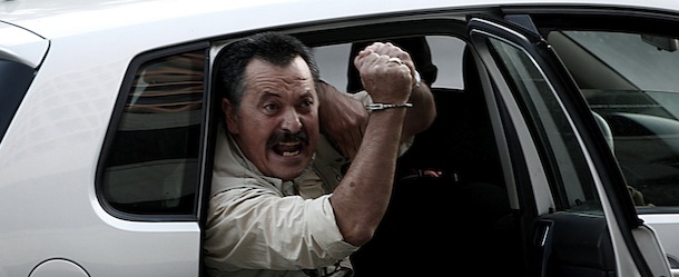 Christos Pappas, lawmaker of the extreme far-right Golden Dawn party, shouts slogans as he sits inside a police car before being escorted to the prosecutor's office from the police headquarters in Athens on September 29, 2013. Greek police swooped on the neo-Nazi Golden Dawn party, arresting its leadership and hunting for dozens of members across the country in a crackdown sparked by the murder of a leftist musician. AFP PHOTO / ANGELOS TZORTZINIS (Photo credit should read ANGELOS TZORTZINIS/AFP/Getty Images)