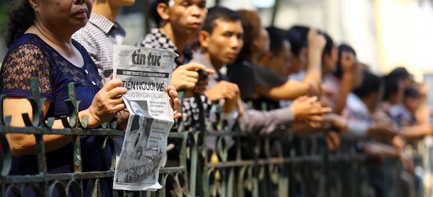 A Vietnamese woman holds a newspaper with the headline of the late General Vo Nguyen Giap on the front page as she stands among thousands of others outside the National Funeral House in Hanoi on October 12, 2013. Vietnam's top leaders gathered to pay their last respects to independence hero General Vo Nguyen Giap, who died last week at 102, as his two-day state funeral began in Hanoi. AFP Photo / Na Son Nguyen / POOL (Photo credit should read Na Son Nguyen/AFP/Getty Images)