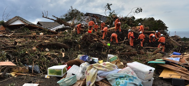 Policemen search for missing people after a landslide on Oshima island, 120 km south of Tokyo on October 18, 2013. Japanese coast guard personnel were October 18 scouring waters off the coast of a Japanese island where landslides buried houses after a huge typhoon rolled through, as the death toll reached 24. AFP PHOTO / KAZUHIRO NOGI (Photo credit should read KAZUHIRO NOGI/AFP/Getty Images)
