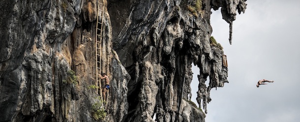 PHI PHI ISLAND, THAILAND &#8211; OCTOBER 24: (EDITORIAL USE ONLY) In this handout image provided by Red Bull, Blake Aldridge (R) of the UK dives from a 25 metre rock at Viking Caves in the Andaman Sea as Michal Navratil (C) of the Czech Republic makes his way up the ladders during competition on the fifth day of the final stop of the 2013 Red Bull Cliff Diving World Series on October 24, 2013 at Phi Phi Island, Thailand. (Photo by Dean Treml/Red Bull via Getty Images)

