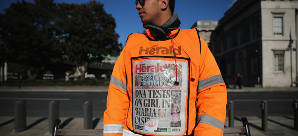 DUBLIN, IRELAND &#8211; OCTOBER 23: A newspaper vendor wears a vest displaying front page of The Herald on October 23, 2013 in Dublin, Ireland. Irish authorities are waiting for DNA test results in relation to a girl removed by Gardai from a Roma family in Dublin, days after a similar case in Greece. The seven-year old girl with blonde hair and blues eyes was taken into care by HSC, Health Service Executive on Monday pending DNA tests. (Photo by Dan Kitwood/Getty Images)
