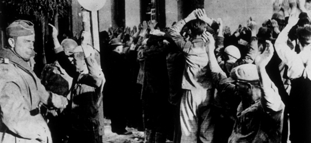 September 1942: This photograph, of a raid on the Jewish ghetto in Warsaw, was found on the body of a German soldier killed on the Russian front. During such raids Jews were lined up in the streets and forced to stand facing a wall with their hands above their heads for long periods. Gestapo agents on the left are searching some of the victims. Beatings, torture or murder would be the likely result of any 8contrabande being found. (Photo by Keystone/Getty Images)

