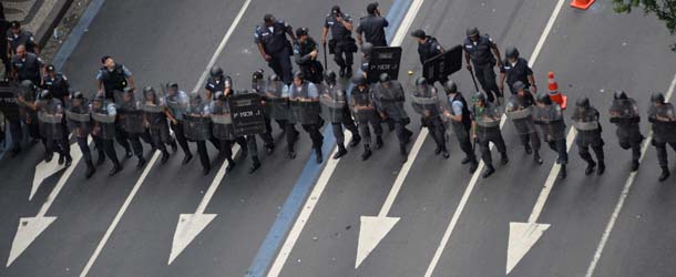 Policemen prepare to confront demonstrators during a teachers' protest in Rio de Janeiro, Brazil on October 1, 2013. Brazil has seen street protests directed towards the country's ruling elite since June, in demand of better public services and an end to political corruption. AFP PHOTO/VANDERLEI ALMEIDA (Photo credit should read VANDERLEI ALMEIDA/AFP/Getty Images)