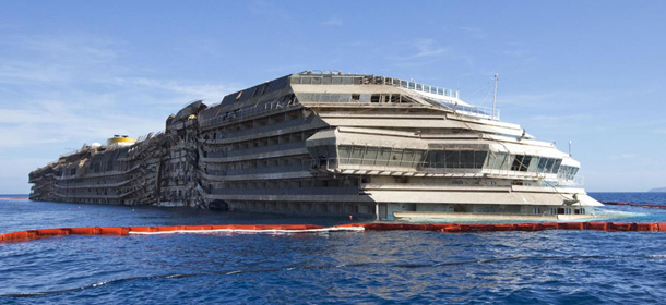 FILE - In this Wednesday, Sept. 18, 2013 file photo, the Costa Concordia is seen after it was lifted upright, on the Tuscan Island of Giglio, Italy. A Dutch salvaging company says it has won a $30 million contract to move the wreck of the Costa Concordia cruise ship next summer to a yet-to-be-determined site for dismantling. Thirty-two people died when the Concordia slammed into a reef off the Tuscan island of Giglio and capsized on Jan. 13, 2012. It was righted in a major operation last month and is now sitting on a platform on the seabed. Royal Boskalis NV said Thursday, Oct. 10, 2013, the cruise ship will be loaded in its entirety onto a huge specialized transport ship. The flat-shaped transport ship &quot;Dockwise Vanguard,&quot; developed for moving oil platforms, works by submerging its middle section so heavy loads can be placed on top of it. The Concordia will be floated into place for transport. (AP Photo/Andrew Medichini, File)