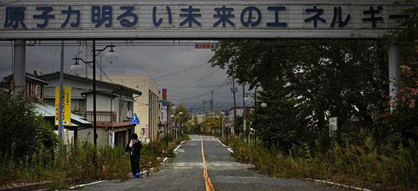 A woman, who came for a brief visit to her home, walks under a sign reading "Nuclear Power - The Energy for a Better Future", at the entrance of the empty Futaba town, inside the exclusion zone in Fukushima prefecture September 22, 2013. Decades ago, the citizens of Japan's Futaba town took such pride in hosting part of the Fukushima Daiichi nuclear complex that they built a sign over a promenade proclaiming that atomic power made their town prosperous. Now, they are scattered around Japan with no clear sign of when they might return to their homes. A total of 160,000 people were ordered to leave their homes around Daiichi plant after the government announced the evacuation following the nuclear disaster in March 2011. Picture taken September 22, 2013. REUTERS/Damir Sagolj (JAPAN - Tags: DISASTER SOCIETY ENVIRONMENT)

ATTENTION EDITORS: PICTURE 34 OF 53 FOR PACKAGE 'BROKEN LIVES OF FUKUSHIMA'. TO FIND ALL IMAGES SEARCH 'FUKUSHIMA DAMIR'
