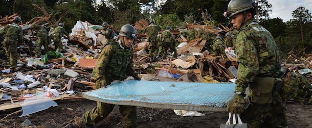 Ground Self-Defense Force rescue members search for survivors after a landslide buried houses caused by heavy rain of typhoon Wipha at Oshima island, 120km south of Tokyo on October 17, 2013. At least 17 people died as a powerful typhoon lashed Japan&#8217;s Pacific coast, with dozens still missing and the death toll likely to rise. AFP PHOTO / KAZUHIRO NOGI (Photo credit should read KAZUHIRO NOGI/AFP/Getty Images)
