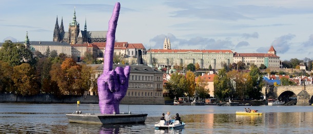 RESTRICTED TO EDITORIAL USE, MANDATORY MENTION OF THE ARTIST UPON PUBLICATION, TO ILLUSTRATE THE EVENT AS SPECIFIED IN THE CAPTION
People sailing on the boats on Vltava River look at the giant purple middle finger sculpture by Czech artist David Cerny on October 21, 2013 in Prague. This artwork installed today, four days before the Czech early general election, on the Vltava River is adressed to Czech president Milos Zeman who&#8217;s residency is at Prague Castle (in background). AFP PHOTO /MICHAL CIZEK (Photo credit should read MICHAL CIZEK/AFP/Getty Images)
