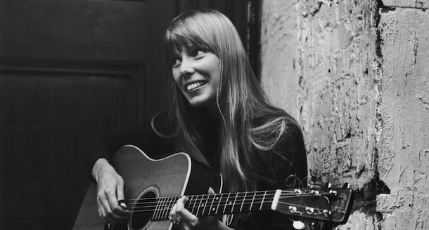 18th September 1968: Canadian folk singer and songwriter Joni Mitchell, strumming her guitar outside The Revolution club in London. (Photo by Central Press/Getty Images)

