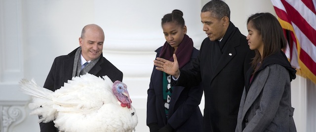 President Barack Obama, with daughters Sasha, second from left, and Malia, right, carries on the Thanksgiving tradition of saving the national turkey, Popcorn, from the dinner table with a "presidential pardon," at the White House in Washington, Wednesday, Nov. 27, 2013, as John Burkel, current chairman of the National Turkey Federation in Badger, Minn, stands left. After the pardoning, Popcorn travels to George Washington’s Mount Vernon Estate and Gardens where they will be on display for visitors during "Christmas at Mount Vernon." (AP Photo/Carolyn Kaster)